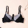 Black bra with leopard print trim on a beige background