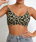 Person wearing a leopard print bralette with gray jeans on a neutral background