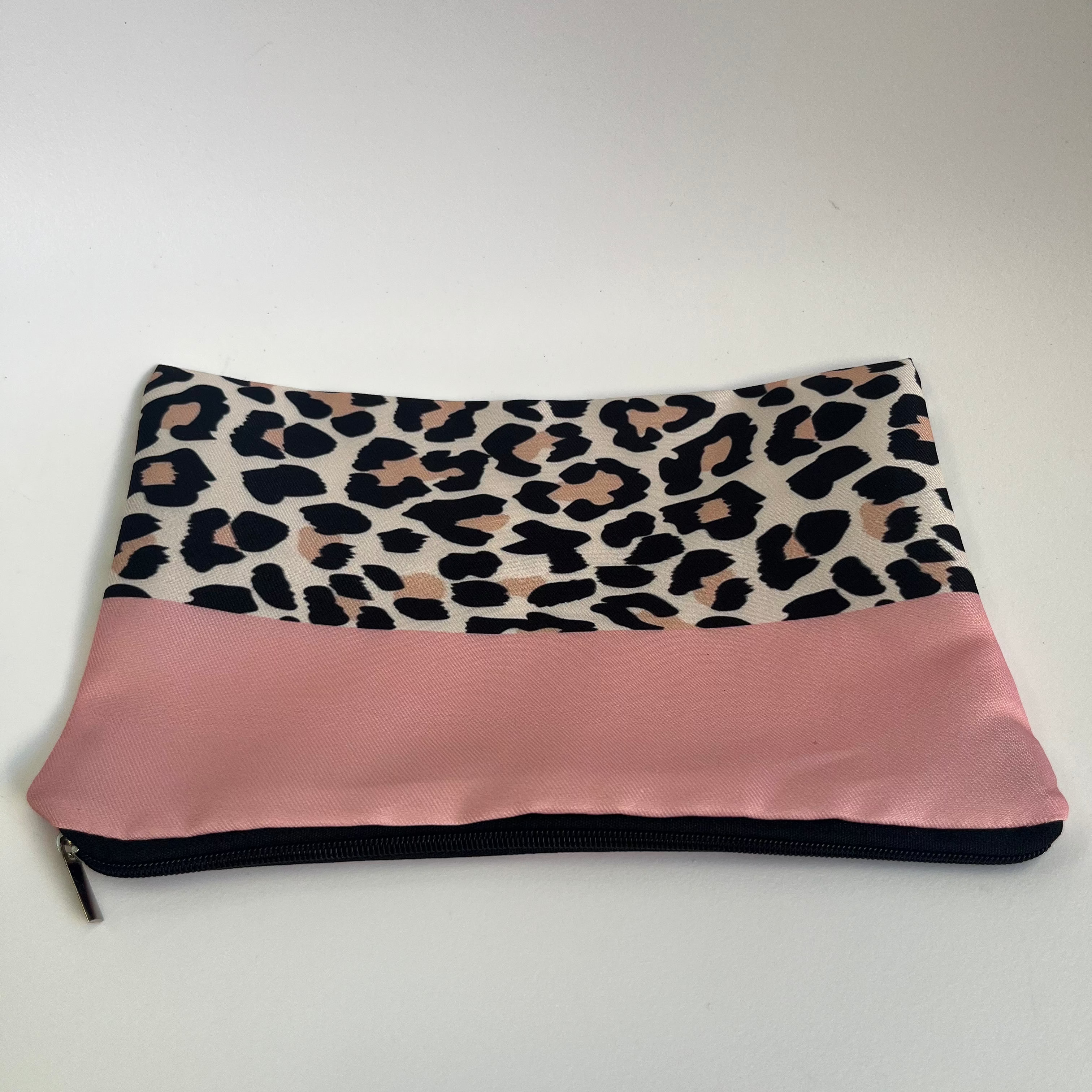 Pouch with leopard print top section and pink bottom section on a white background